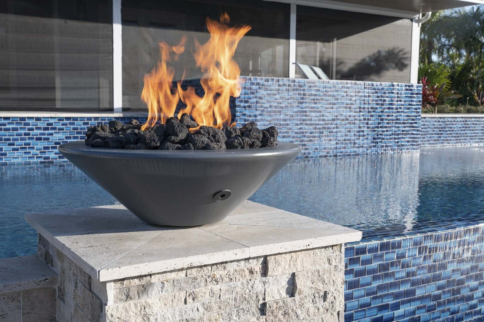 Pool area with elegant fire bowls and dramatic lighting design in Jensen Beach, Florida